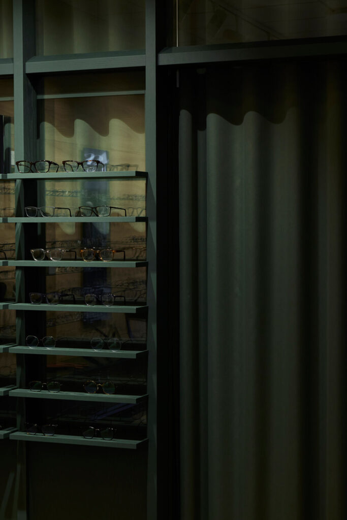 Egetræsreoler hos Optik Nicolai’s i Roskilde med glashylder og kobberdetaljer, specialinventar og opbevaringsløsninger i butikken.