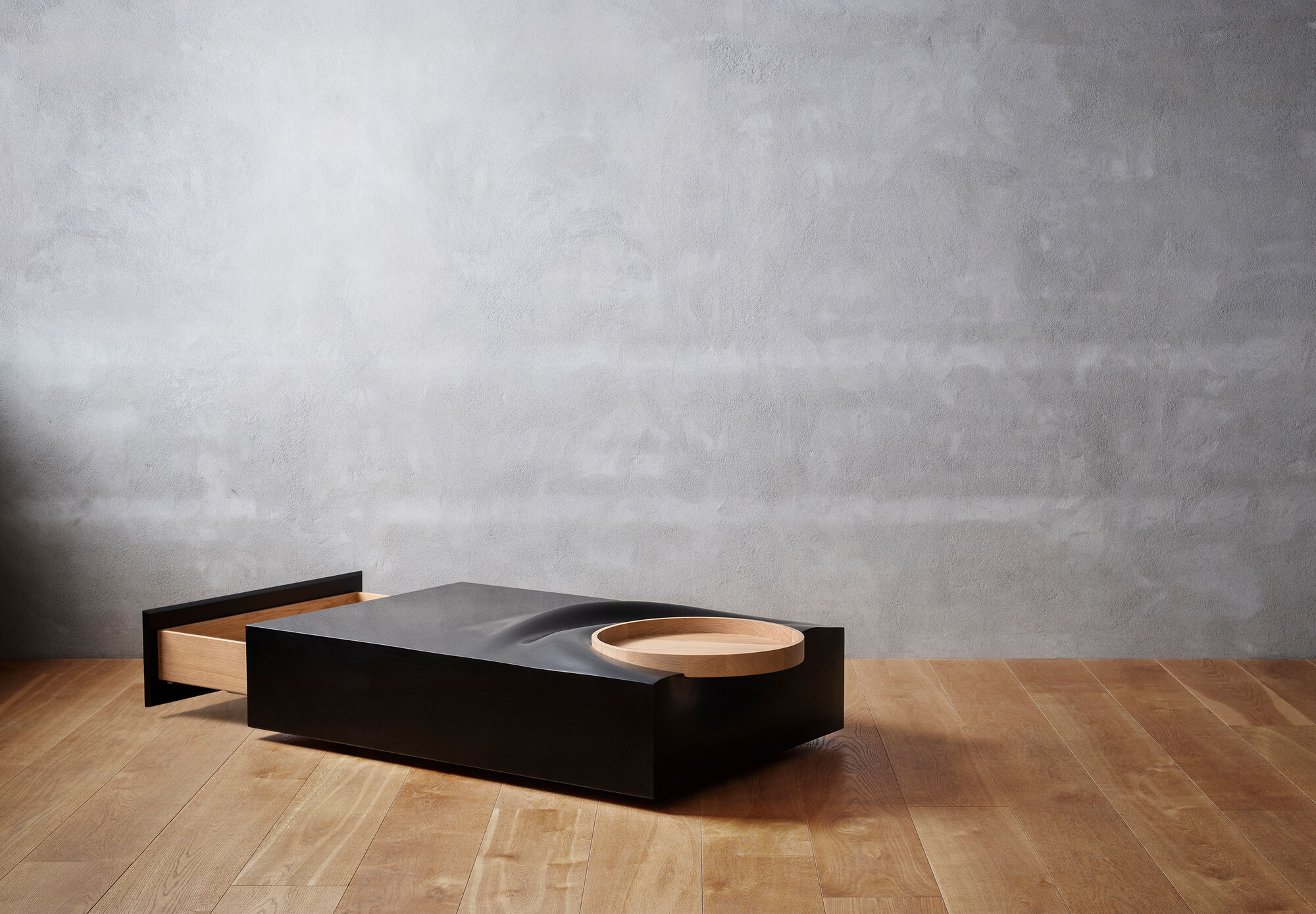 Loungebord designet af Anne Boysen, med opbevaring og aftagelig bakke. Bordet er fremstillet i sort Corian og massiv eg.