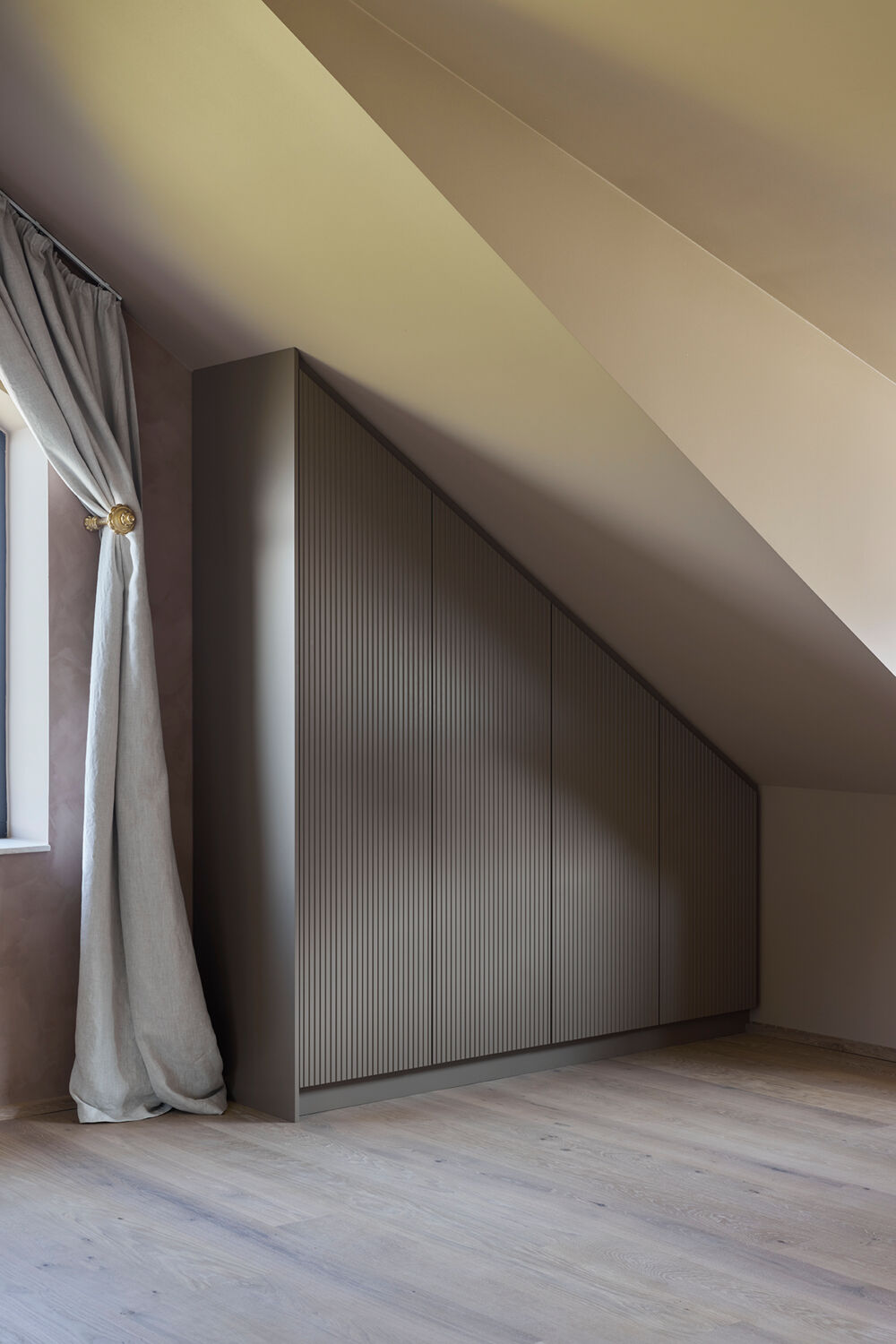 Specialbyggede garderobeskabe til skrå vægge i sove- og børneværelser, tilpasset rum, funktion og indretning.