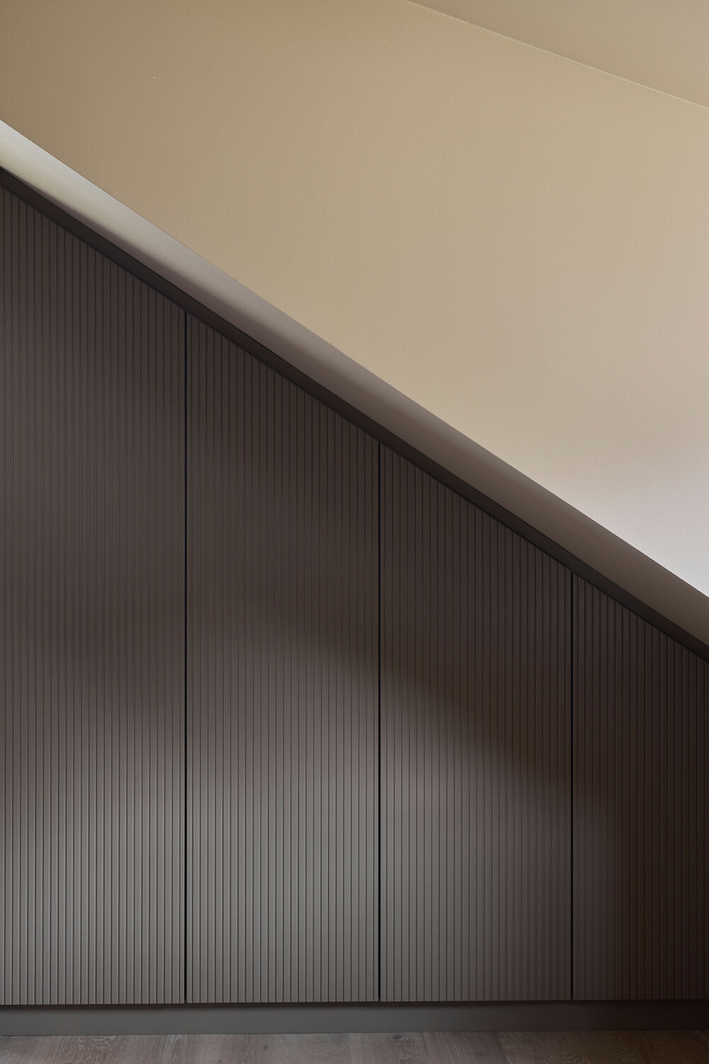 Specialbyggede garderobeskabe til skrå vægge i sove- og børneværelser, tilpasset rum, funktion og indretning.