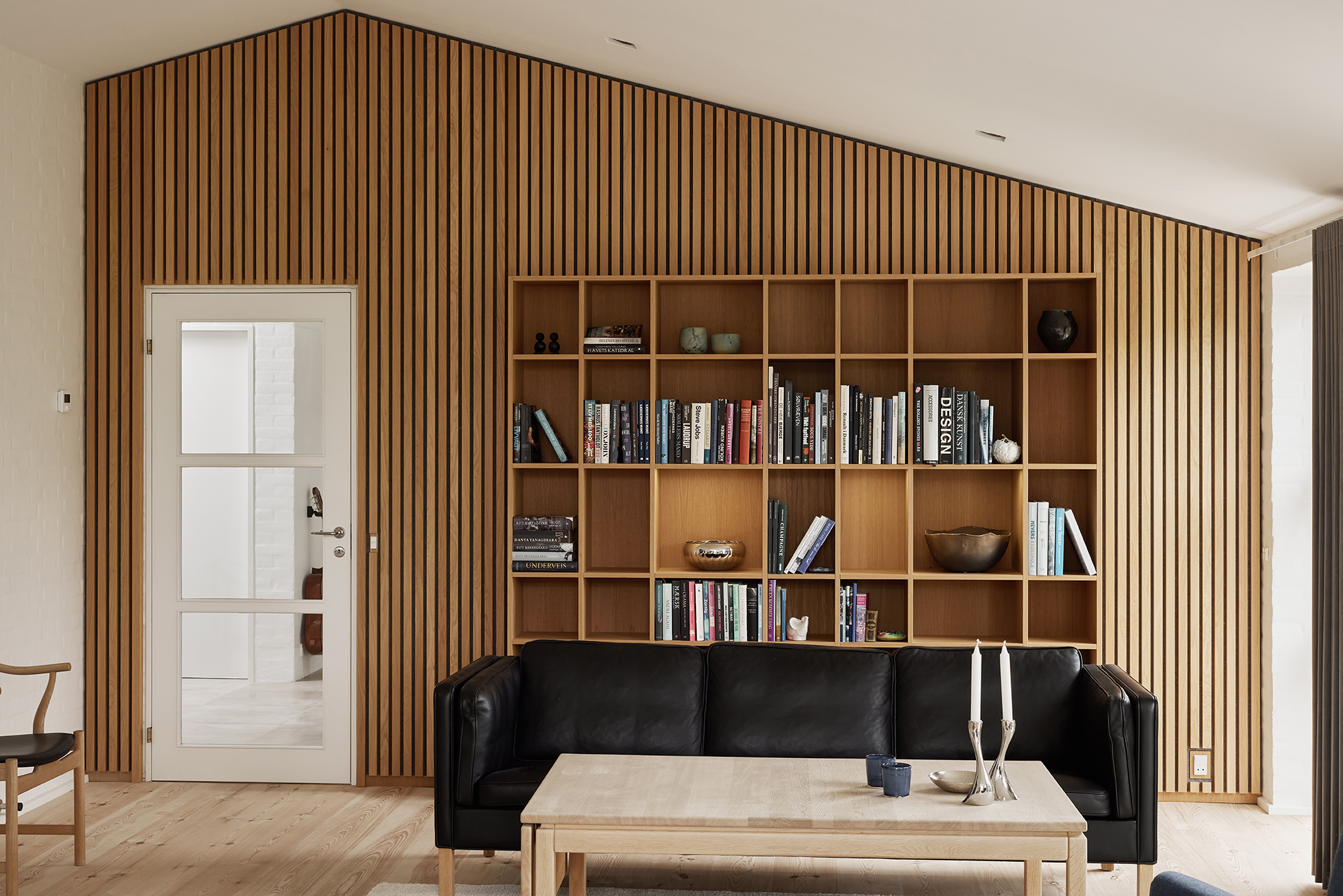 Med en praktisk vægreol og akustikpanel, fik familien optimeret rummets funktionalitet, samt tilføjet en ro, varme og god opbevaringsløsning.